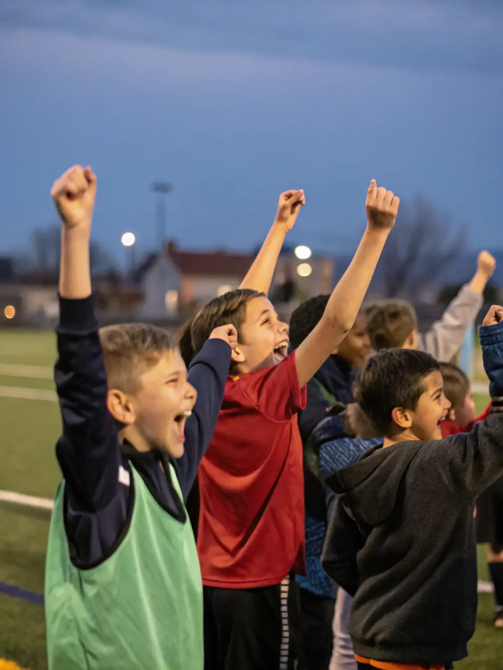 A group of children laughing and high-fiving after a soccer game, symbolizing teamwork and camaraderie within ASSOCIATION SPORTIVE.